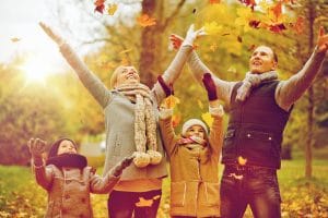 Boise Home Inspectors a family throwing leaves and enjoying the autumn season
