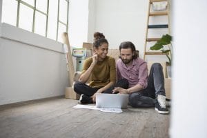 Boise Home Inspectors man and woman sitting on a floor searching something with their laptop