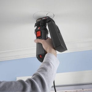 Boise Home Inspectors putting whole in the ceilings using home improvement tool