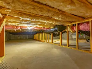 Crawl space with insulation, ductwork, and framing in a Boise, ID home during inspection.