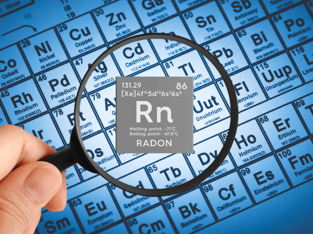 Magnifying glass highlighting Radon (Rn) on the periodic table for radon testing in Boise, ID.