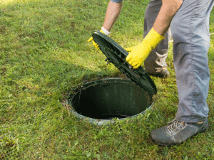 Technician opening sewer access cover in Boise, ID for inspection.